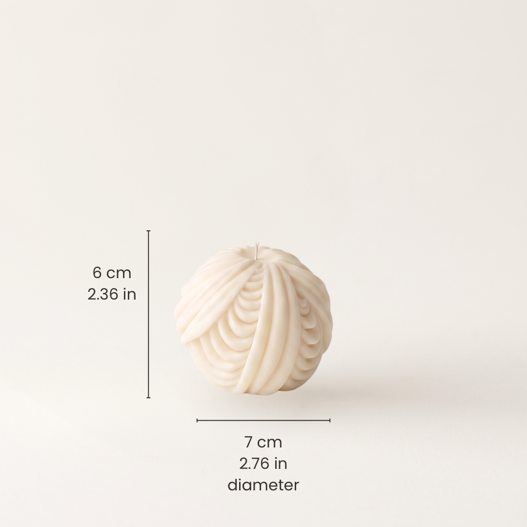 An off-white textured spherical candle with a ribbed pattern, shown with black dimension lines and text indicating a height of 6 cm (2.36 in) and a diameter of 7 cm (2.76 in)