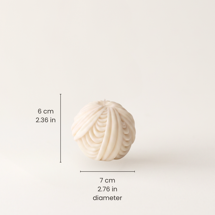 An off-white textured spherical candle with a ribbed pattern, shown with black dimension lines and text indicating a height of 6 cm (2.36 in) and a diameter of 7 cm (2.76 in)