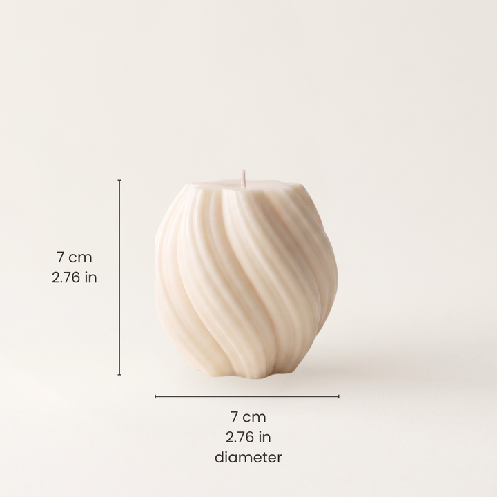 A cream-colored ribbed pillar candle shown on a light beige background with black dimension lines and text indicating a height of 7 cm (2.76 in) and a diameter of 7 cm (2.