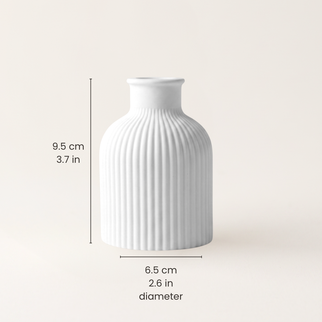 A white ribbed ceramic vase centered on a light beige background, with dimension lines and text showing a height of 9.5 cm (3.